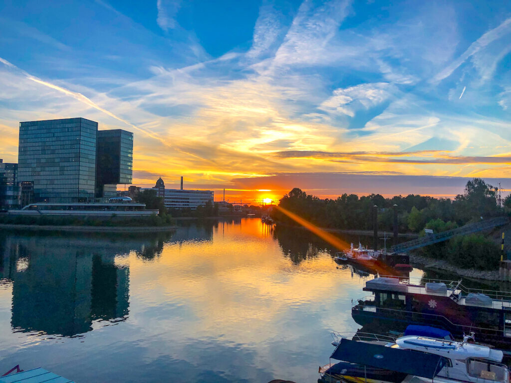 Blick über Wasser auf Düsseldorf Medienhafen bei Sonnenuntergang